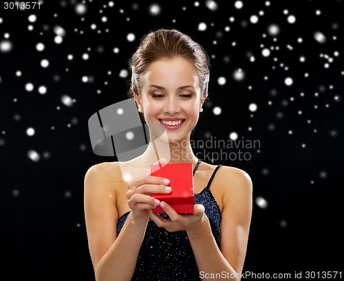 Image of smiling woman holding red gift box