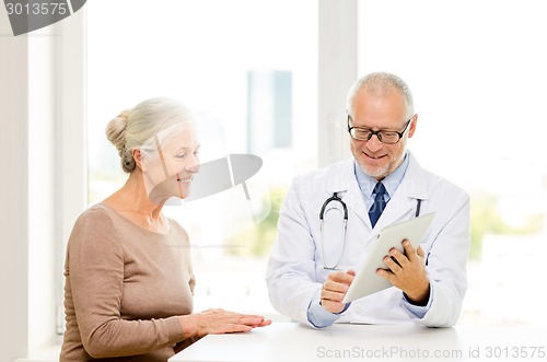 Image of smiling senior woman and doctor with tablet pc