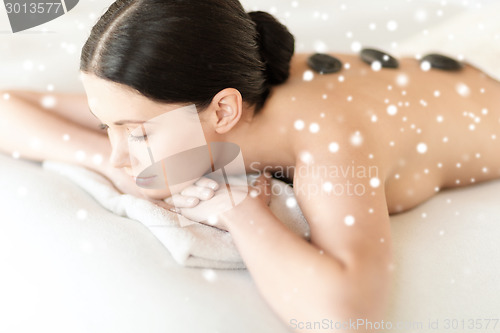 Image of woman in spa salon with hot stones