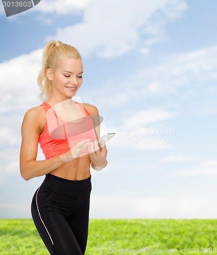 Image of smiling sporty woman with smartphone