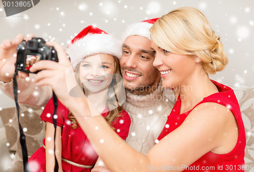 Image of happy family with digital camera taking photo