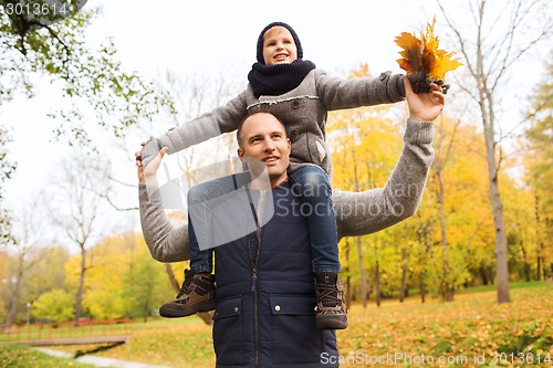 Image of happy family having fun in autumn park