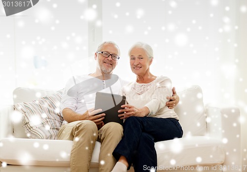 Image of happy senior couple with tablet pc at home