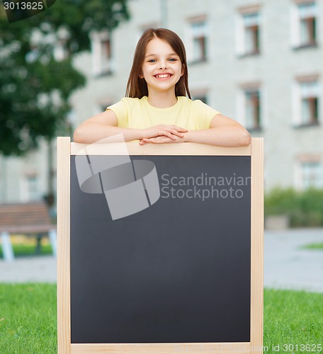 Image of happy little girl with blank blackboard