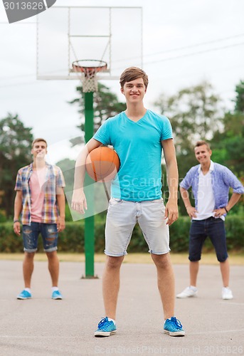 Image of group of smiling teenagers playing basketball