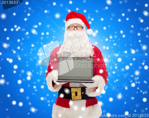 Image of man in costume of santa claus with laptop