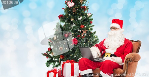 Image of man in costume of santa claus with laptop