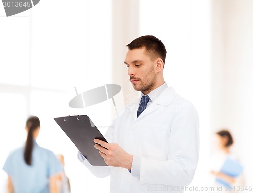 Image of serious male doctor with clipboard