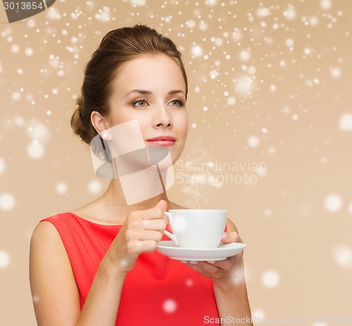 Image of smiling woman in red dress with cup of coffee