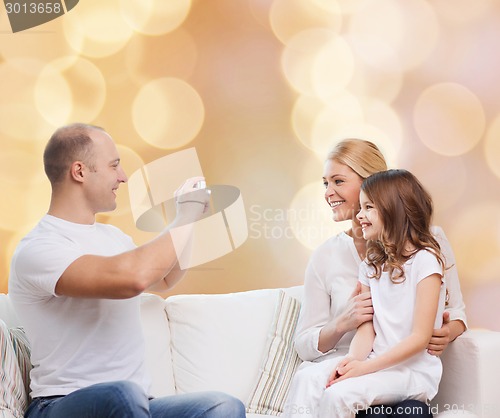 Image of happy family with camera at home