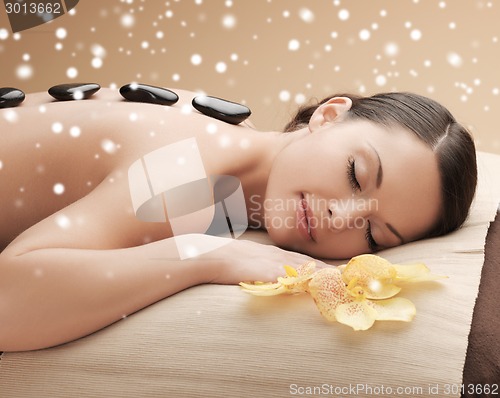 Image of woman in spa salon with hot stones
