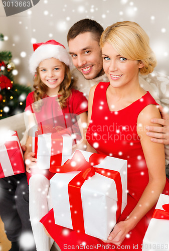 Image of smiling family holding many gift boxes