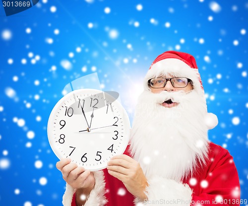 Image of man in costume of santa claus with clock