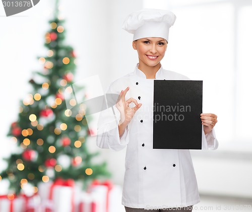 Image of smiling female chef with black blank paper