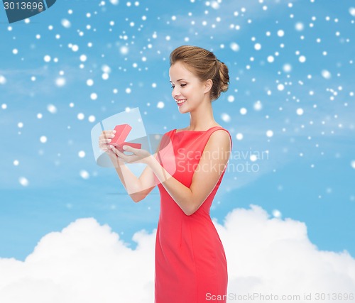 Image of smiling young woman in red dress with gift box