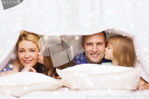 Image of happy family with two kids under blanket at home