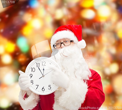 Image of man in costume of santa claus with clock