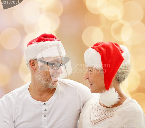 Image of happy senior couple in santa helper hats