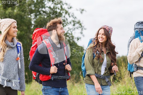 Image of group of smiling friends with backpacks hiking
