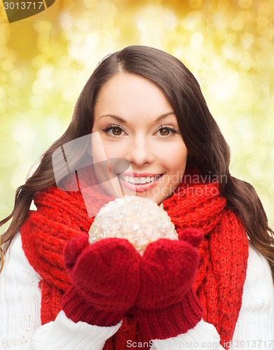 Image of smiling woman in winter clothes with snowball