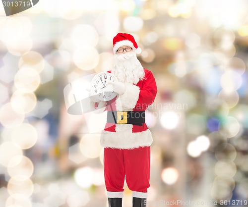 Image of man in costume of santa claus with clock