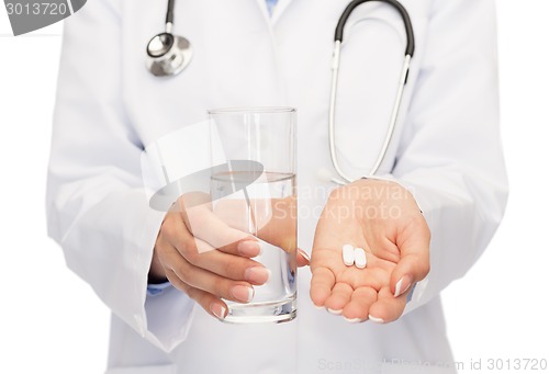 Image of close up of doctor offering pills and water