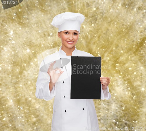 Image of smiling female chef with black blank paper