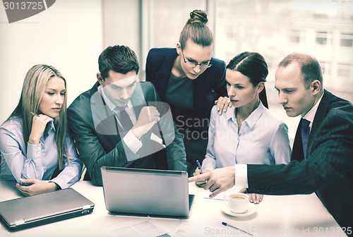 Image of business team with laptop having discussion