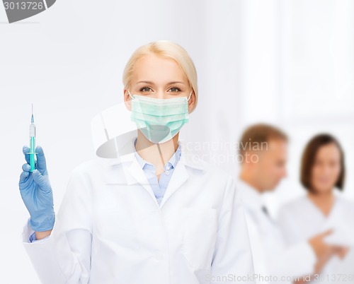 Image of doctor in mask holding syringe with injection