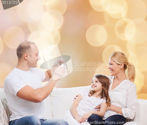 Image of happy family with camera at home