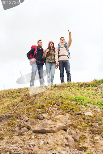 Image of group of smiling friends with backpacks hiking