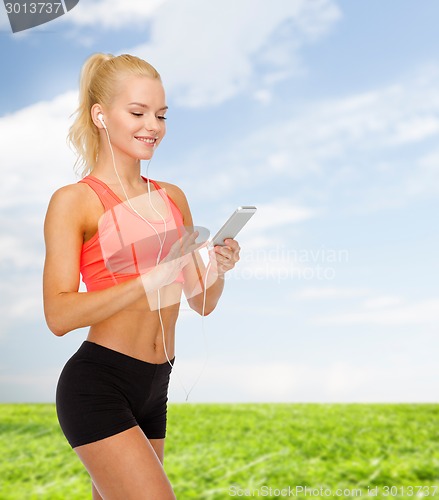 Image of smiling sporty woman with smartphone and earphones