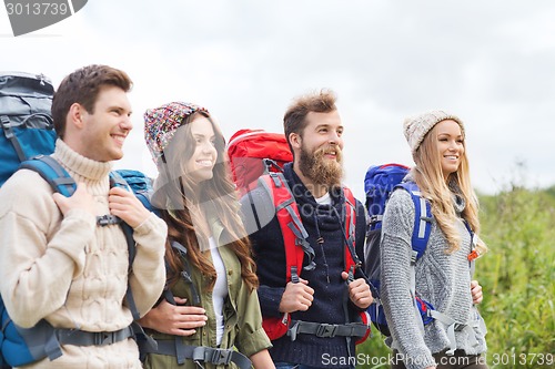 Image of group of smiling friends with backpacks hiking