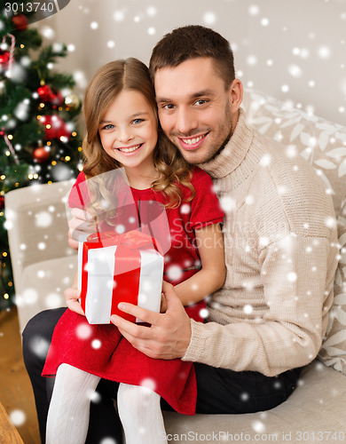 Image of smiling father and daughter holding gift box