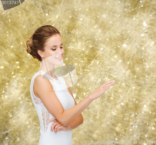 Image of smiling woman in white dress with diamond ring