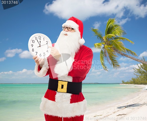 Image of man in costume of santa claus with clock