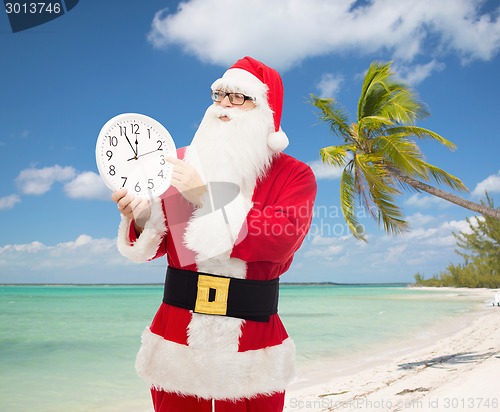 Image of man in costume of santa claus with clock