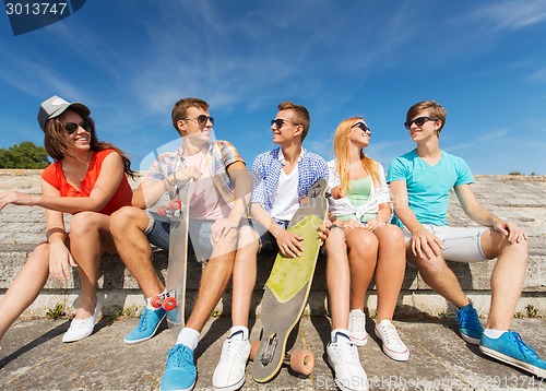 Image of group of smiling friends sitting on city street