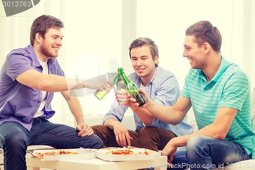 Image of smiling friends with beer and pizza hanging out