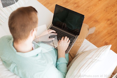 Image of close up of man working with laptop at home