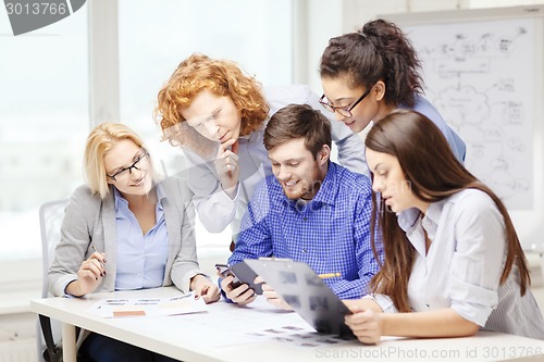 Image of creative team with papers and clipboard at office