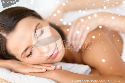 Image of beautiful young woman in spa salon getting massage