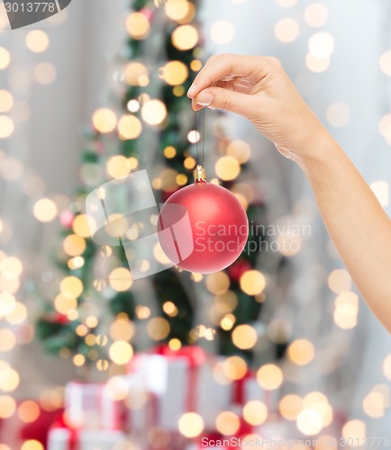 Image of close up of woman in sweater with christmas ball