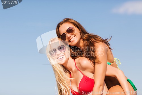 Image of two smiling young women on beach