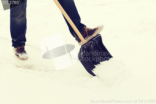 Image of closeup of man shoveling snow from driveway