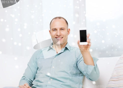Image of smiling man showing blank smartphone screen