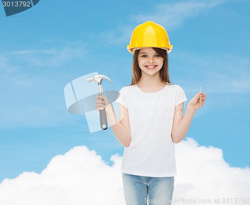 Image of smiling little girl in hardhat with hammer