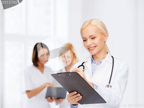 Image of smiling female doctor with clipboard