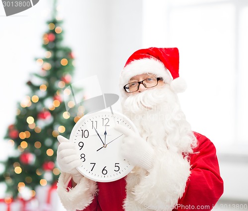 Image of man in costume of santa claus with clock