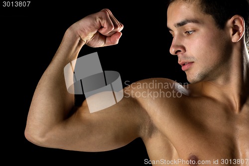 Image of close up of young man showing biceps